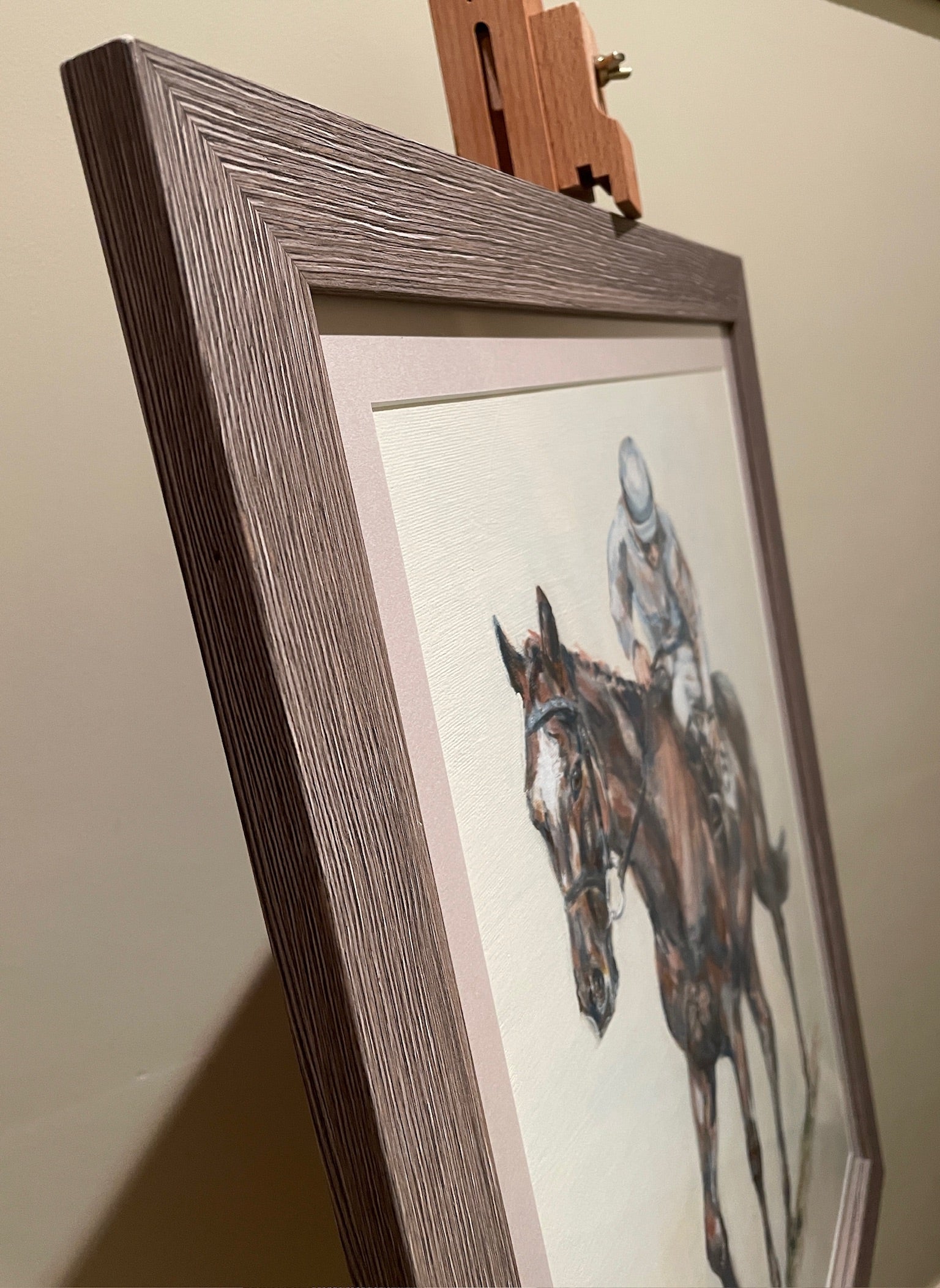 This painting is the study of a jockey checking his girth before the start of the race. The composition is from an interesting angle of perspective and the muted palette accentuates the quiet ritual of the preparatory checks before the thrilling act of horseracing.