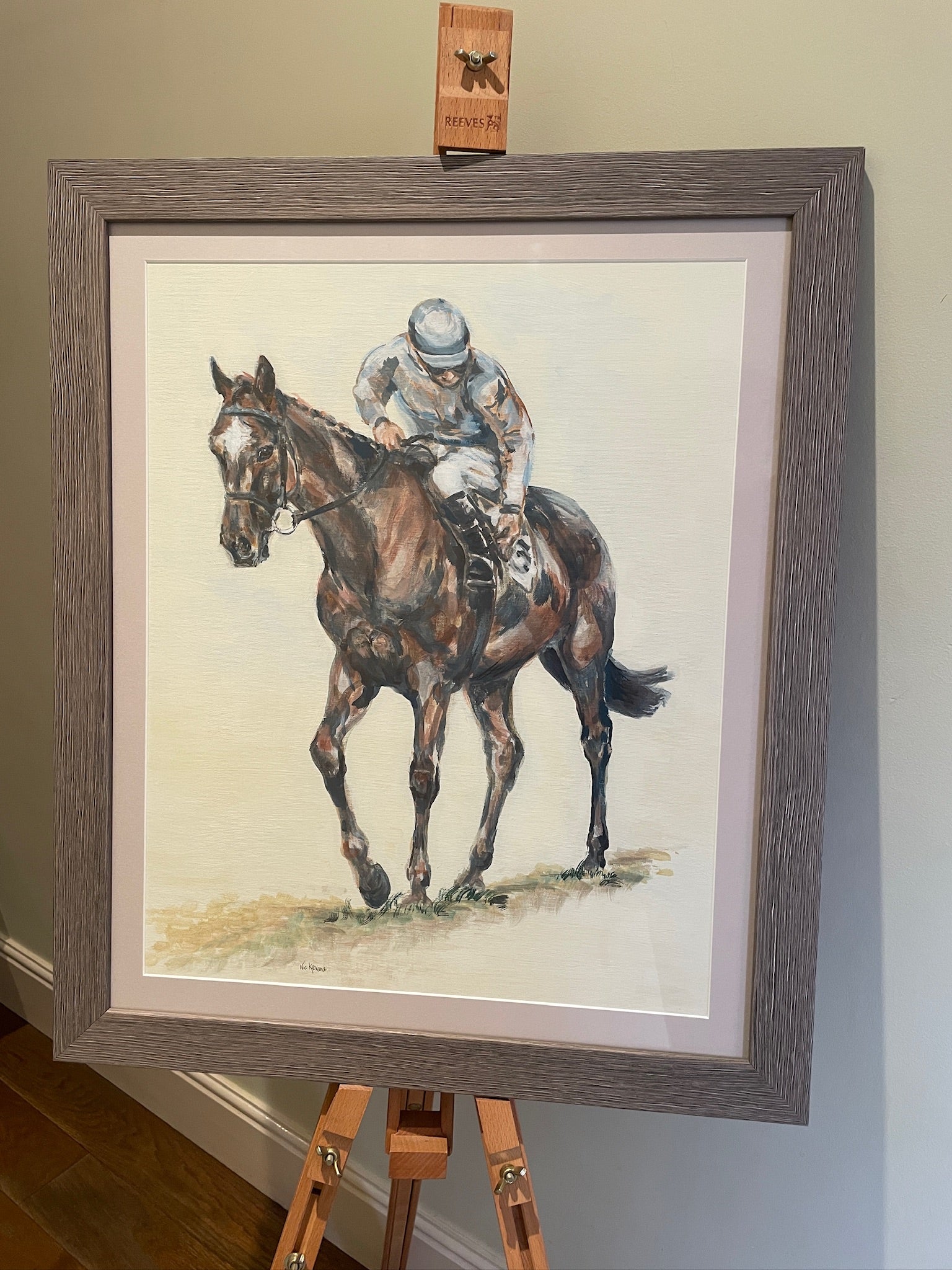 This painting is the study of a jockey checking his girth before the start of the race. The composition is from an interesting angle of perspective and the muted palette accentuates the quiet ritual of the preparatory checks before the thrilling act of horseracing. 