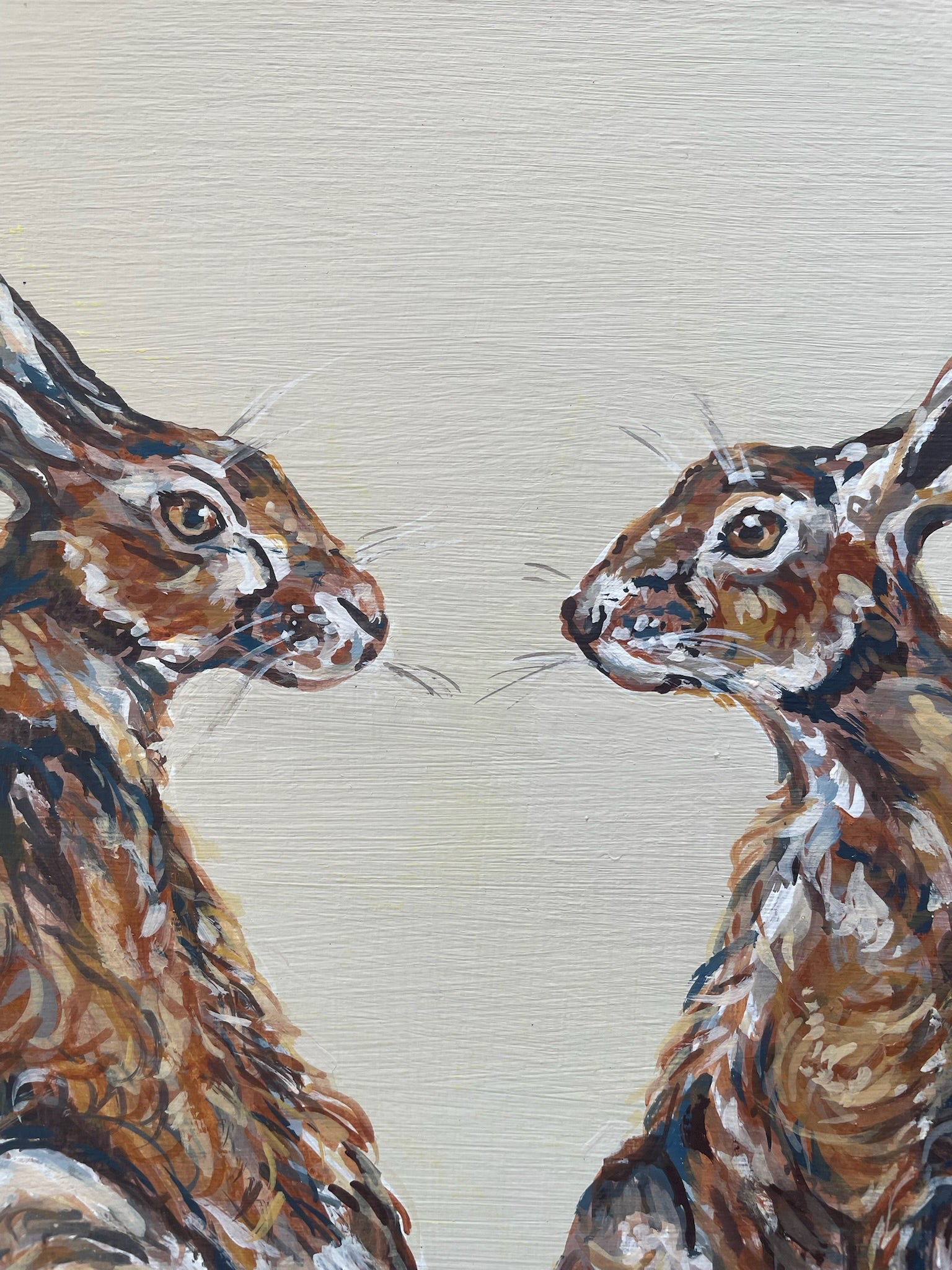 This painting features two hares in a heart shaped composition.   These characterful hares have been spied before they leap across the countryside meadow.