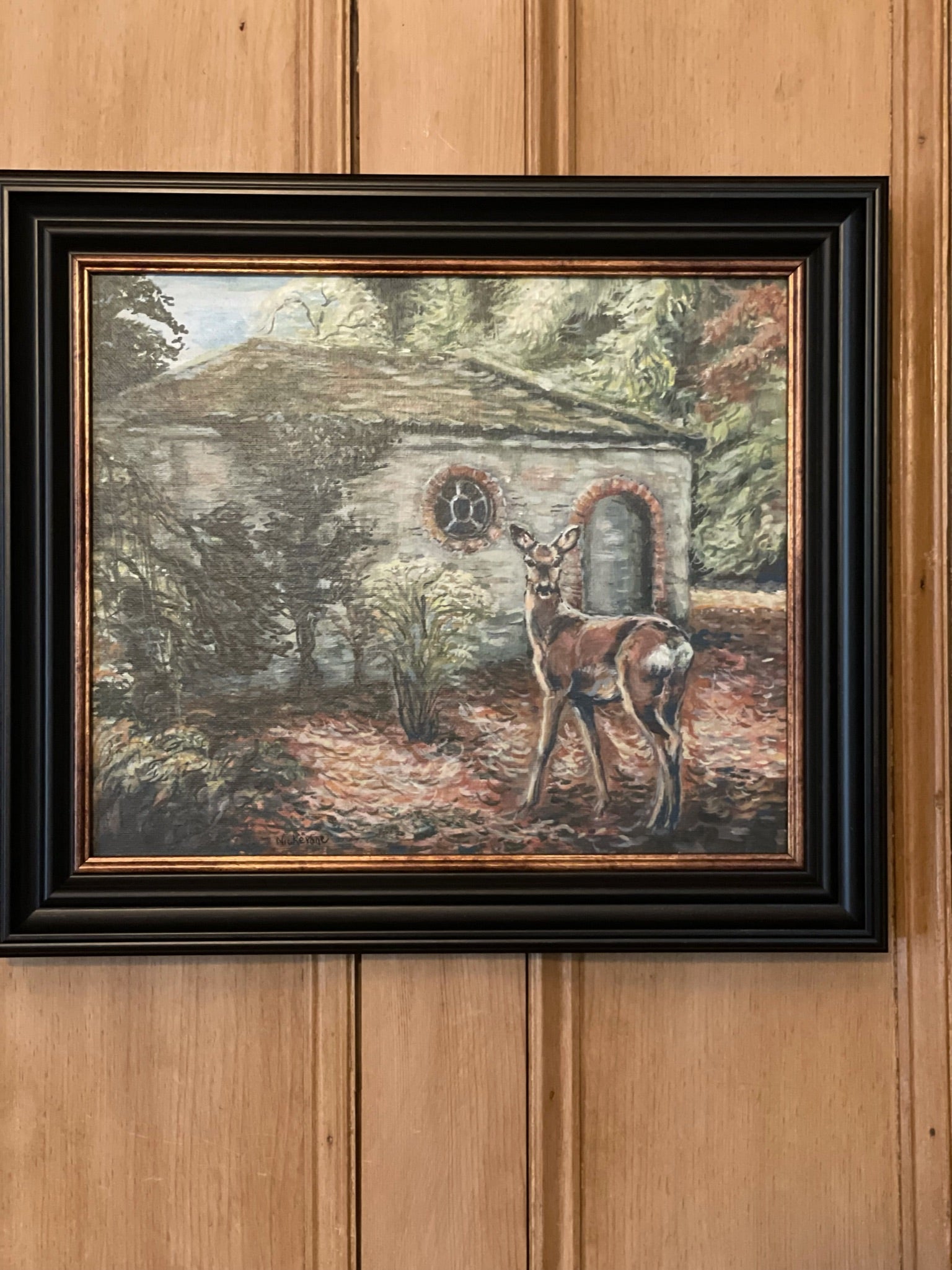 A painting of a roe deer in a woodland landscape. The surprised deer is glimpsed by the viewer near an old picturesque shelter in the woods.