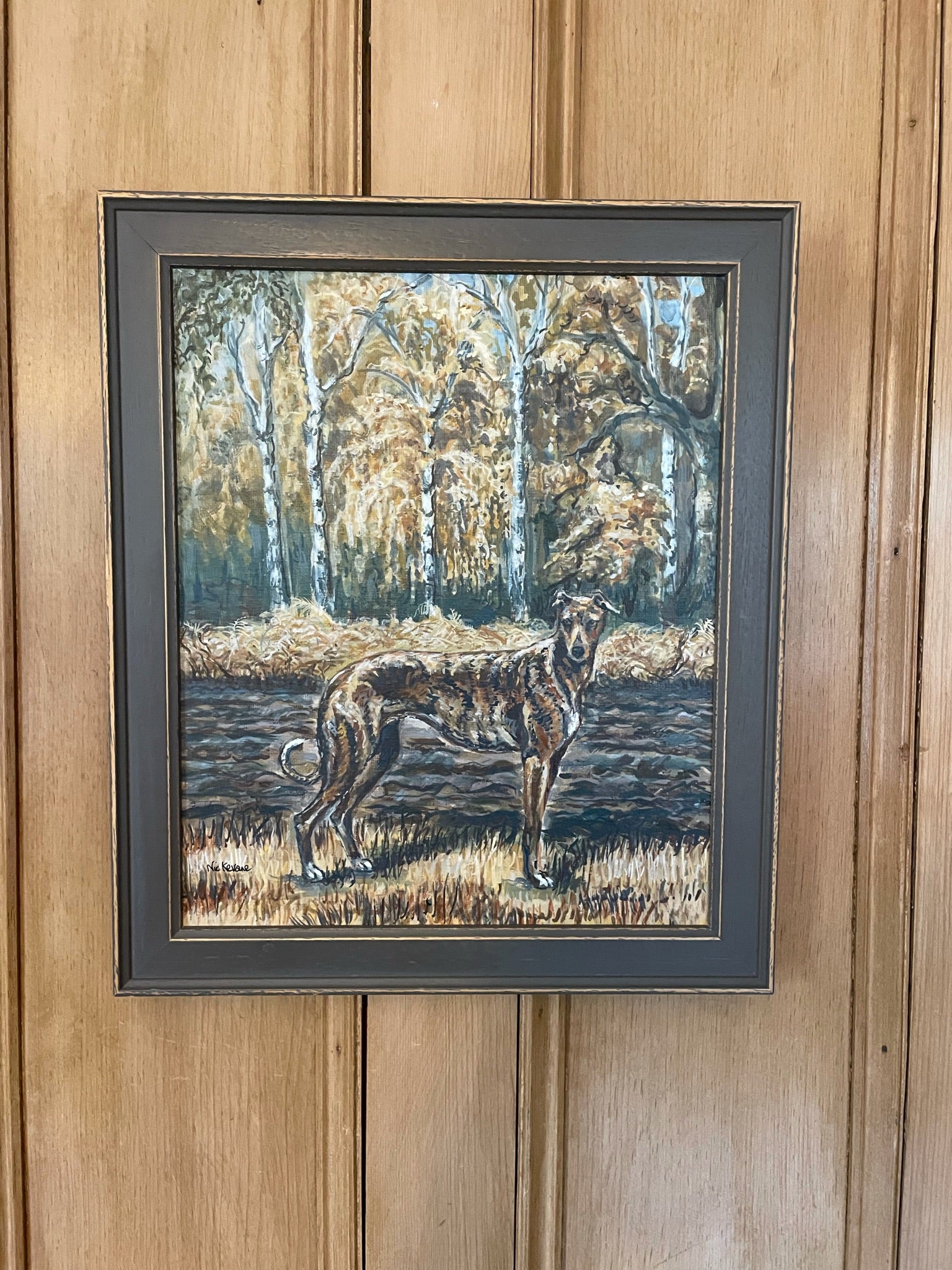 An original painting of a brindle greyhound standing, in camouflage with the autumn coloured countryside surroundings.